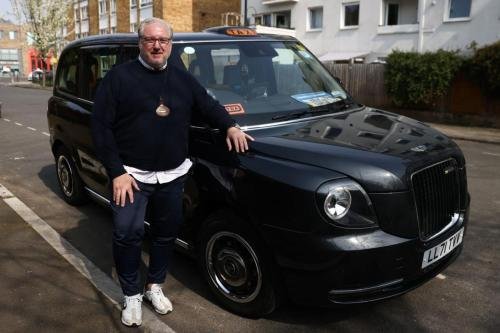 London black cab driver Matt Westfall, 52, poses for photos during a Reuters interview in London